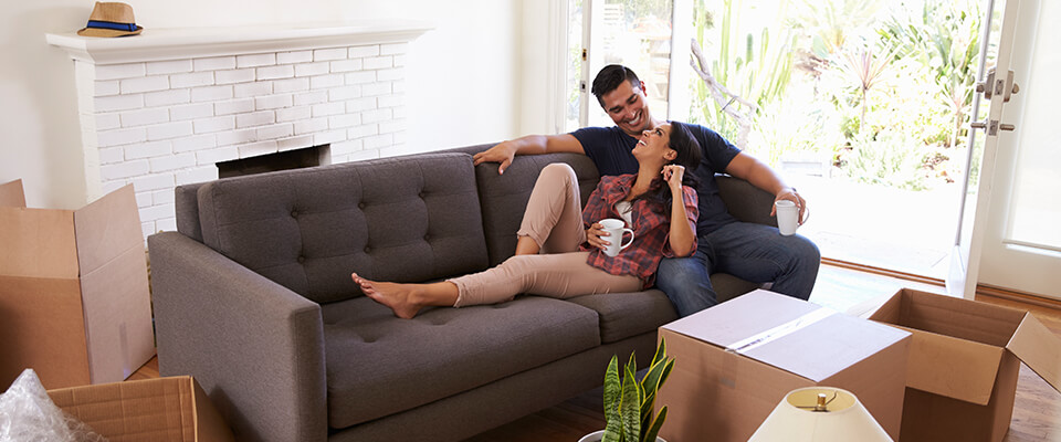Couple sitting on couch taking a break from unpacking