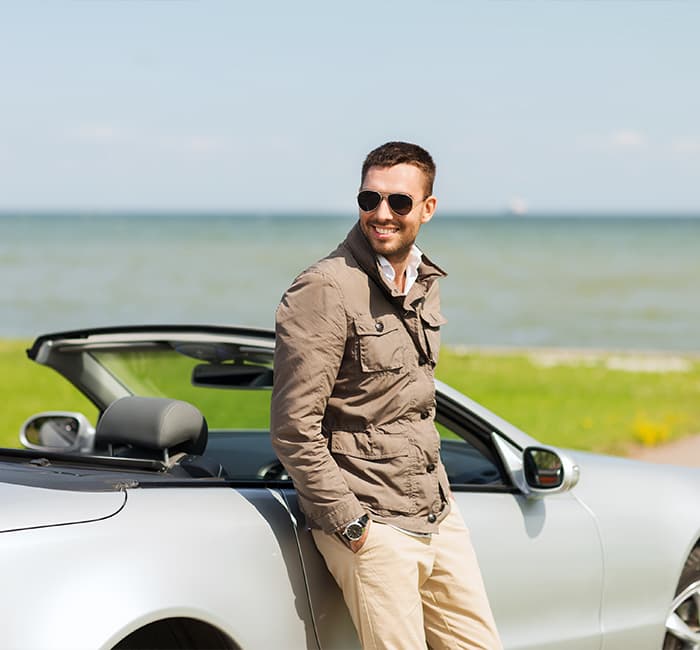 Man standing beside his convertable car